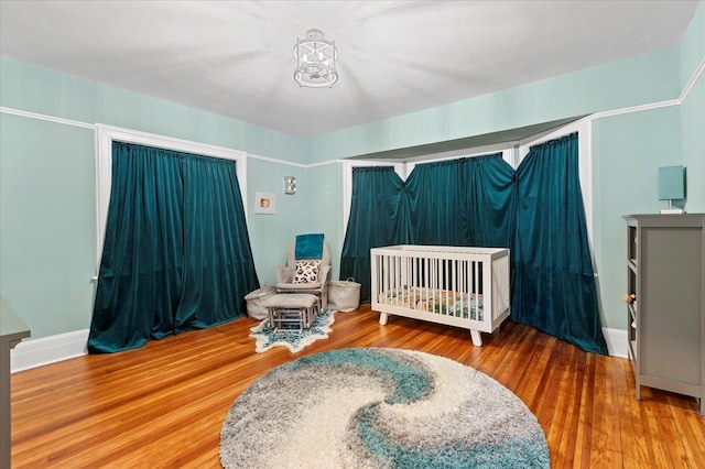 1833 Asbury Ave, Evanston, IL 60201 - bedroom featuring a chandelier, a crib, and wood finished floors