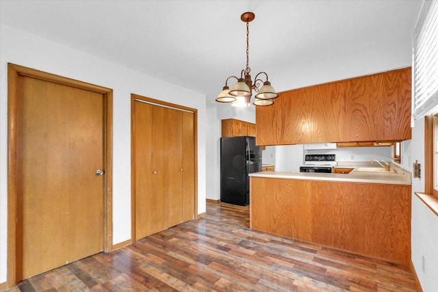 2506 S Cottage Grove Ave, Urbana, IL 61801 - kitchen featuring range with electric cooktop, freestanding refrigerator, a sink, brown cabinetry, and wood finished floors