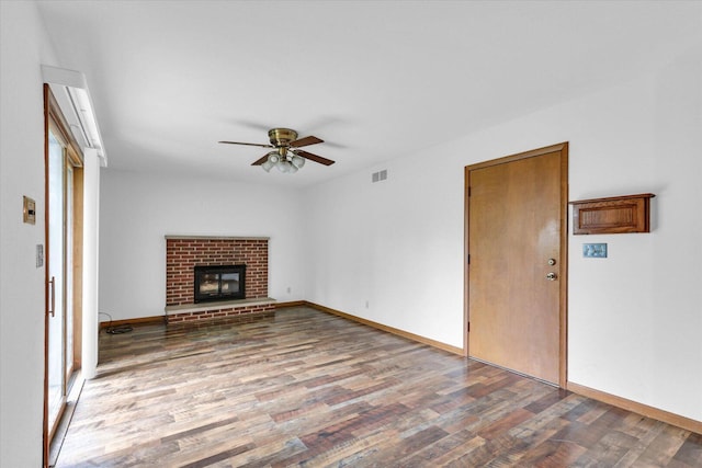 2506 S Cottage Grove Ave, Urbana, IL 61801 - unfurnished living room with wood finished floors, ceiling fan, baseboards, and a brick fireplace
