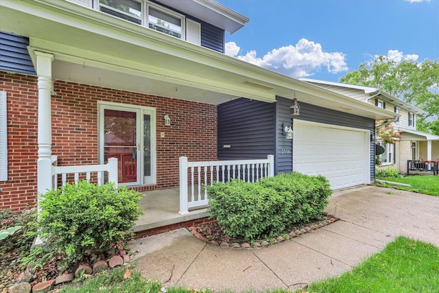 2506 S Cottage Grove Ave, Urbana, IL 61801 - view of exterior entry with a porch, brick siding, concrete driveway, and a garage