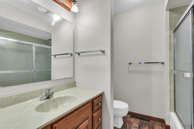 2506 S Cottage Grove Ave, Urbana, IL 61801 - bathroom featuring vanity, toilet, wood finished floors, baseboards, and enclosed tub / shower combo