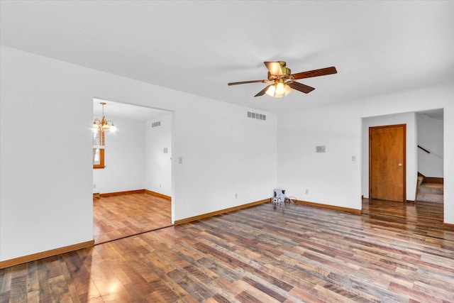 2506 S Cottage Grove Ave, Urbana, IL 61801 - unfurnished room featuring wood finished floors, stairway, ceiling fan, baseboards, and a chandelier