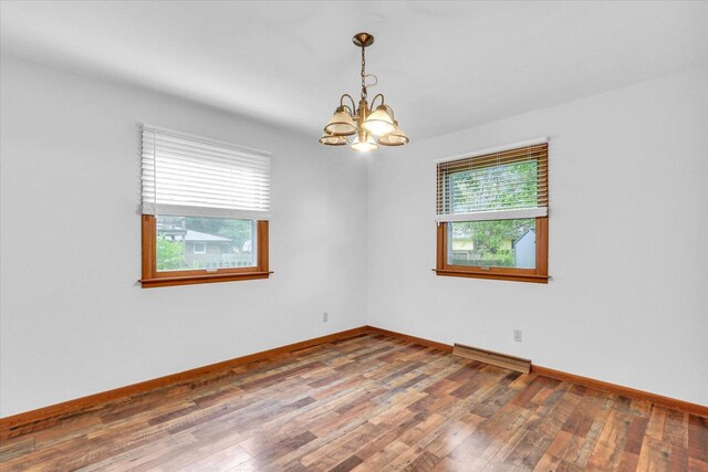 2506 S Cottage Grove Ave, Urbana, IL 61801 - unfurnished room with a chandelier, wood finished floors, baseboards, and a baseboard heating unit