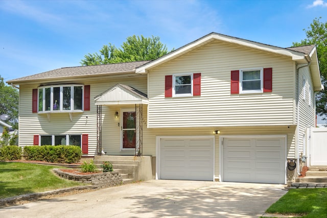 24221 S Edwin Dr, Channahon, IL 60410 - bi-level home featuring an attached garage, concrete driveway, a front lawn, and a shingled roof