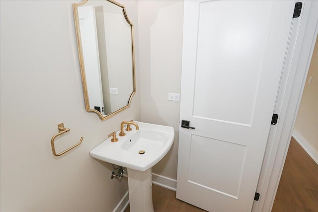 bathroom with baseboards and wood finished floors