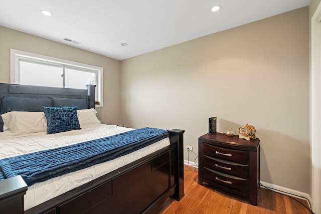 bedroom with baseboards, visible vents, light wood finished floors, and recessed lighting