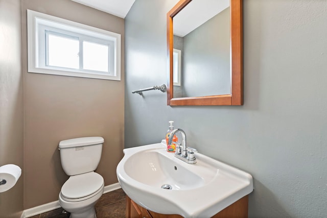 bathroom featuring baseboards, toilet, and vanity