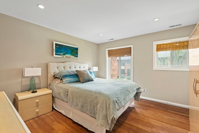 bedroom featuring visible vents, light wood-style flooring, and baseboards