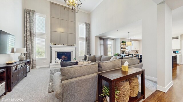 11050 Deer Haven Ln, Orland Park, IL 60467 - living room with a towering ceiling, a high end fireplace, baseboards, light wood-style floors, and a chandelier