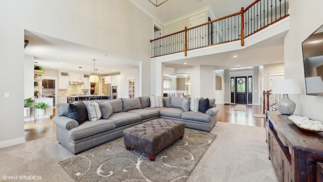 11050 Deer Haven Ln, Orland Park, IL 60467 - living room featuring a towering ceiling, light wood finished floors, baseboards, crown molding, and recessed lighting