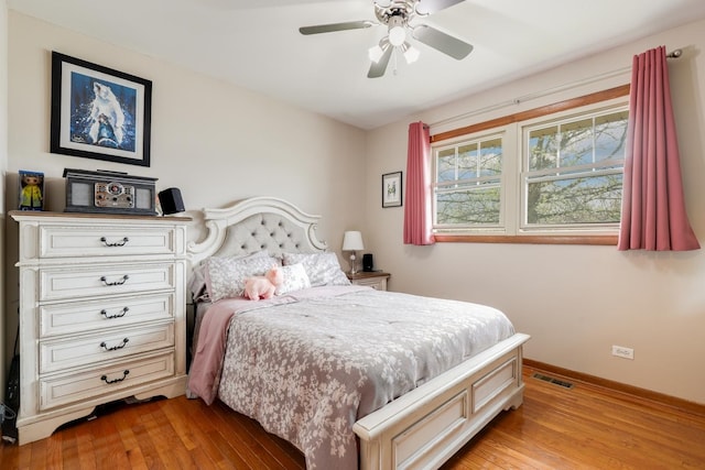 bedroom featuring baseboards, ceiling fan, light wood-style flooring, and visible vents