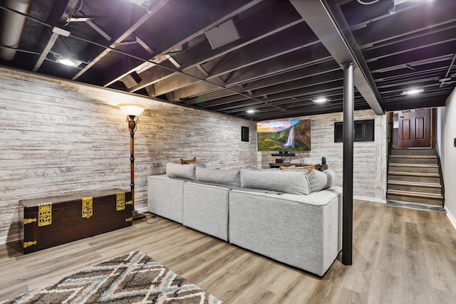 living area with wood walls, wood finished floors, and stairs