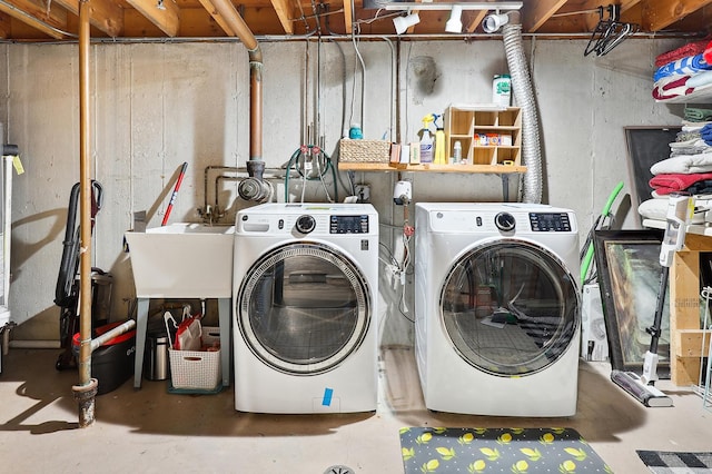 washroom with a sink, laundry area, and washing machine and clothes dryer