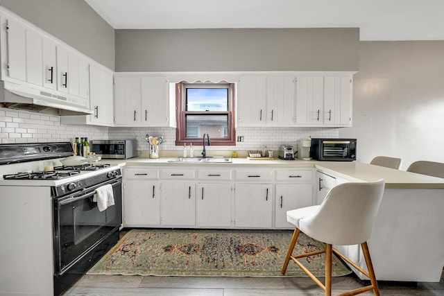 13134 S Burley Ave, Chicago, IL 60633 - kitchen with gas stove, stainless steel microwave, under cabinet range hood, a sink, and a peninsula
