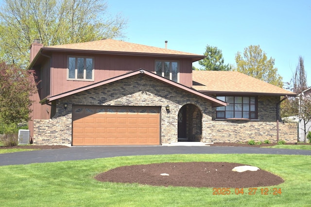 view of front of home with roof with shingles, a chimney, a front lawn, and aphalt driveway
