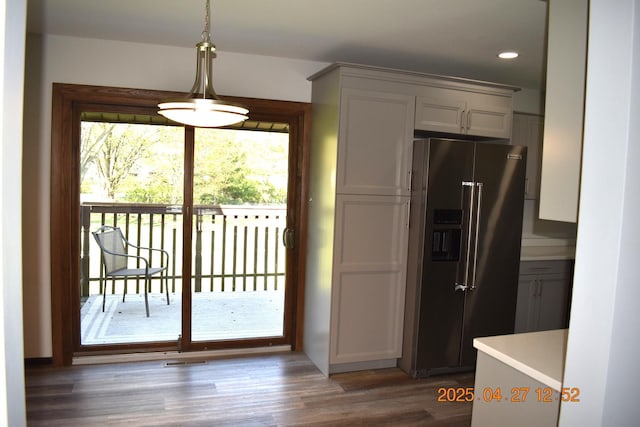 kitchen featuring pendant lighting, high quality fridge, wood finished floors, light countertops, and recessed lighting