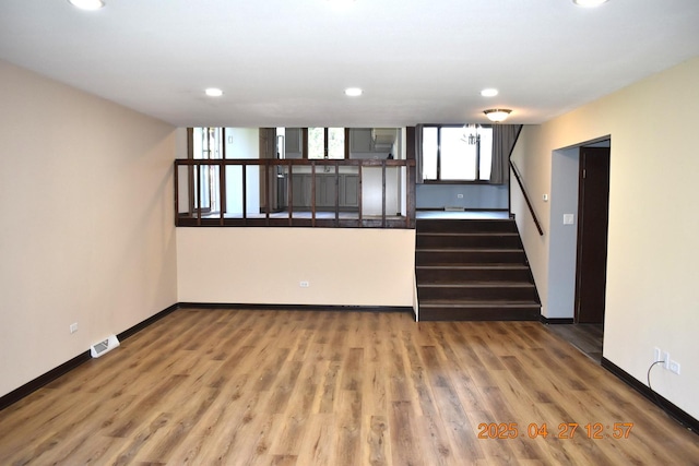 unfurnished living room featuring stairs, recessed lighting, baseboards, and visible vents