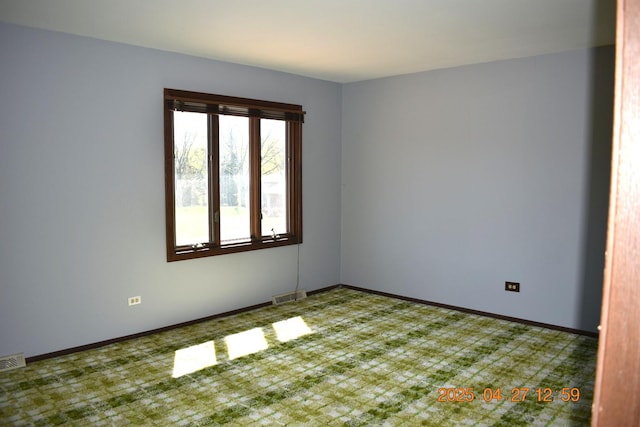 carpeted spare room featuring baseboards and visible vents