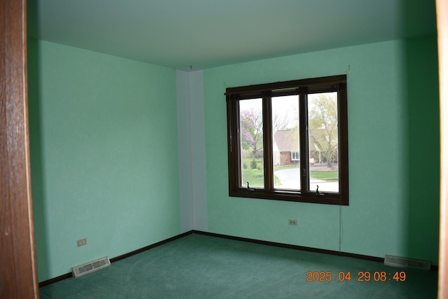 carpeted spare room with baseboards and visible vents