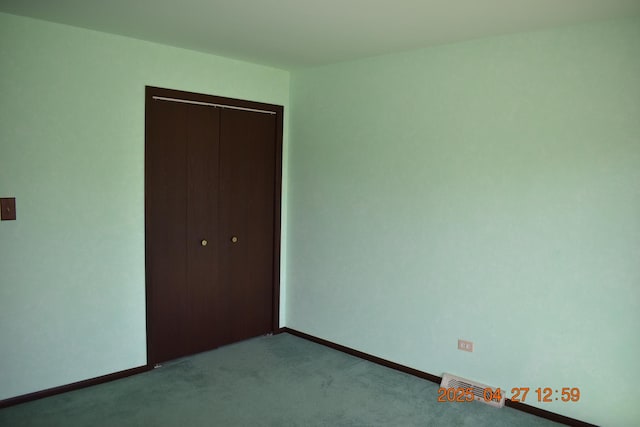unfurnished bedroom featuring baseboards, carpet, and a closet