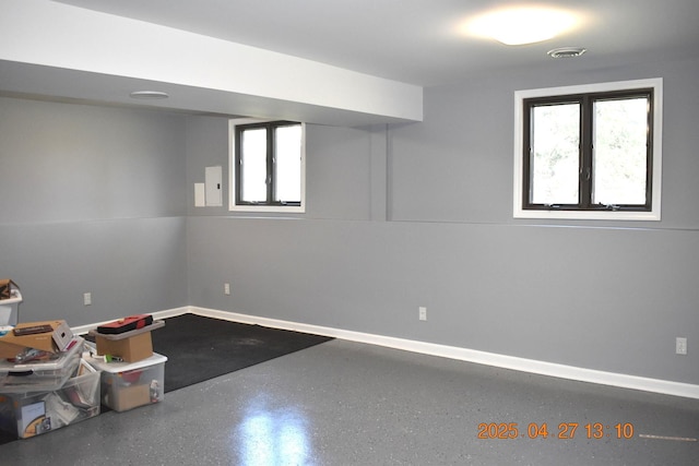 below grade area with baseboards, plenty of natural light, and visible vents