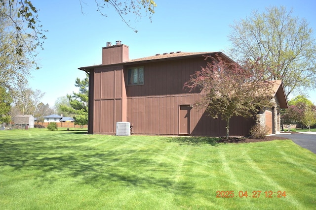 view of barn with a garage, a yard, and cooling unit