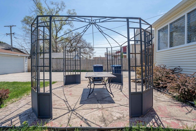 view of patio / terrace with fence and an outdoor structure