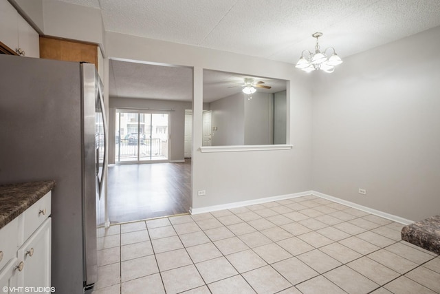 5351 N E River Rd Unit 101, Chicago, IL 60656 - interior space featuring baseboards, ceiling fan with notable chandelier, a textured ceiling, and light tile patterned flooring