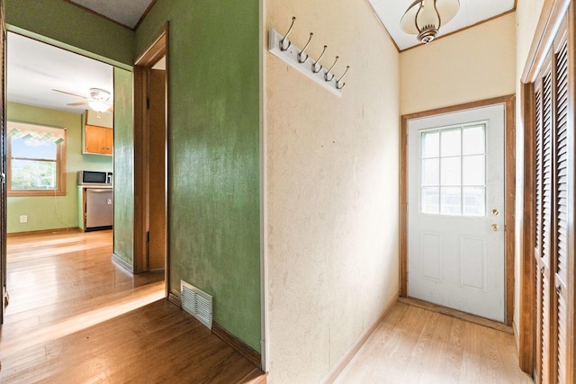 doorway to outside featuring wood finished floors, a ceiling fan, and baseboards