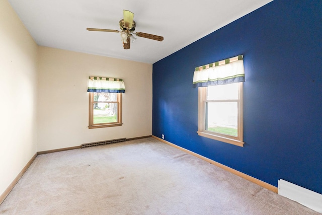 spare room featuring healthy amount of natural light, carpet floors, ceiling fan, and baseboards