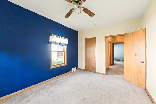 unfurnished bedroom with carpet, baseboards, and a ceiling fan