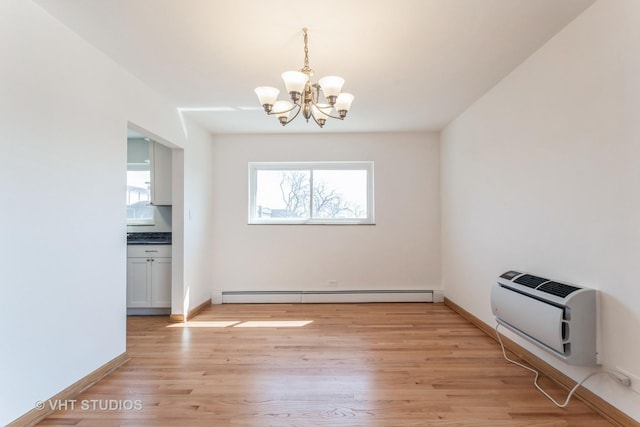 unfurnished dining area featuring a chandelier, light wood-style floors, baseboard heating, baseboards, and heating unit