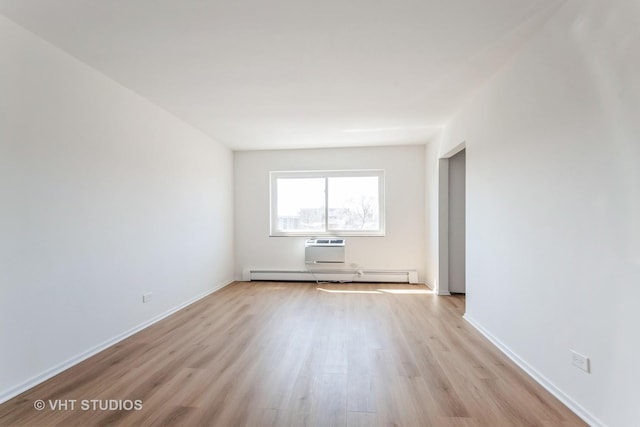 unfurnished room with light wood finished floors, baseboard heating, and baseboards