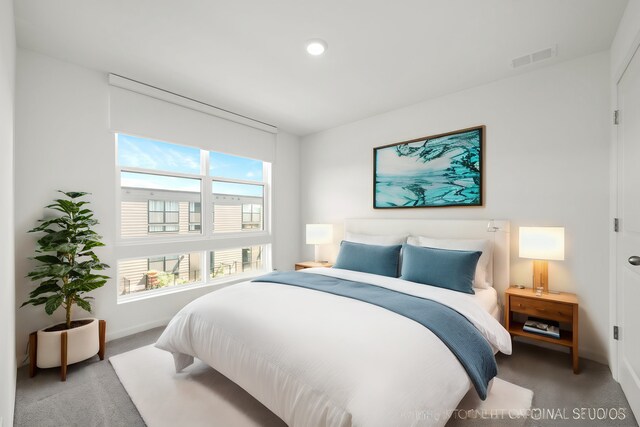 carpeted bedroom featuring baseboards, visible vents, and recessed lighting