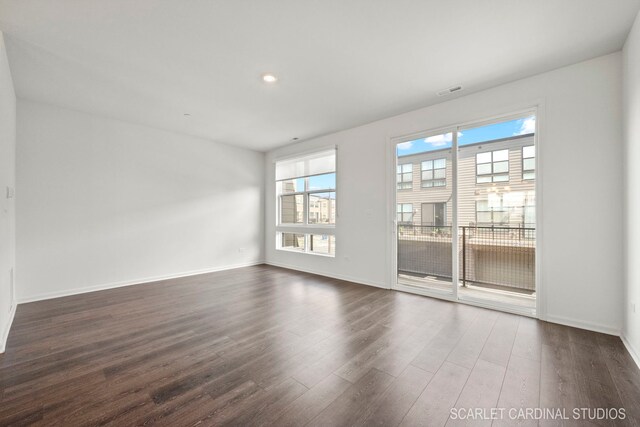 empty room with recessed lighting, visible vents, baseboards, and dark wood finished floors