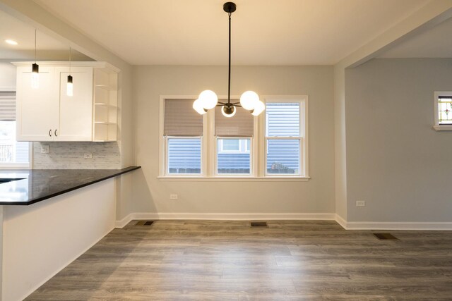 218 157th St, Calumet City, IL 60409 - unfurnished dining area with a chandelier, plenty of natural light, visible vents, and dark wood-style floors
