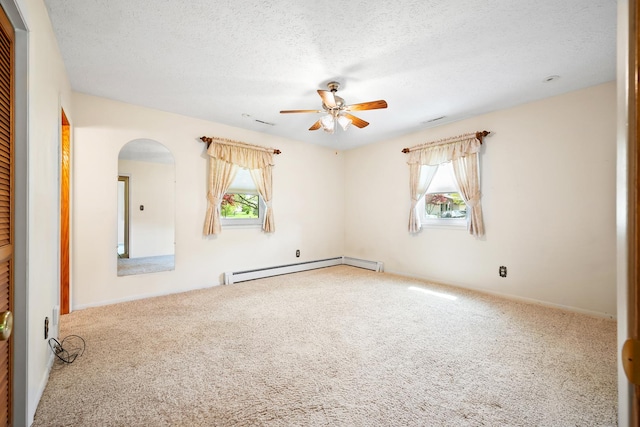 unfurnished room featuring arched walkways, ceiling fan, carpet, and a wealth of natural light