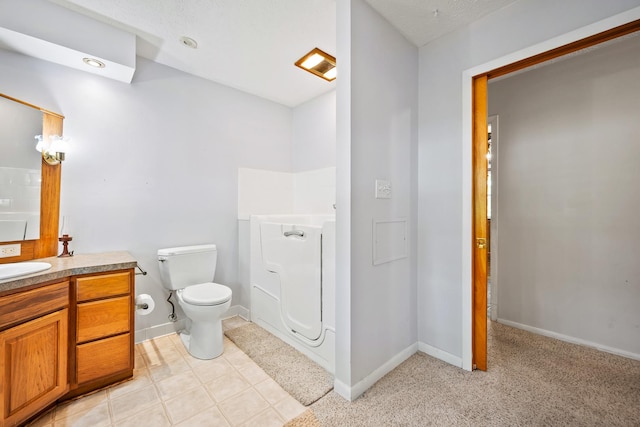 bathroom with baseboards, vanity, and toilet