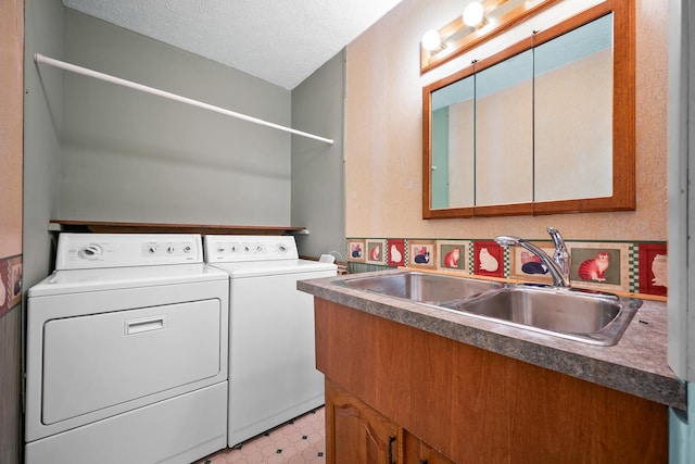 laundry area featuring laundry area, a textured ceiling, a sink, light floors, and washer and dryer