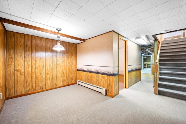 finished below grade area with stairway, carpet floors, a baseboard radiator, and wood walls