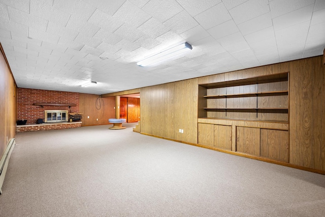unfurnished living room with baseboards, wood walls, carpet flooring, and a fireplace