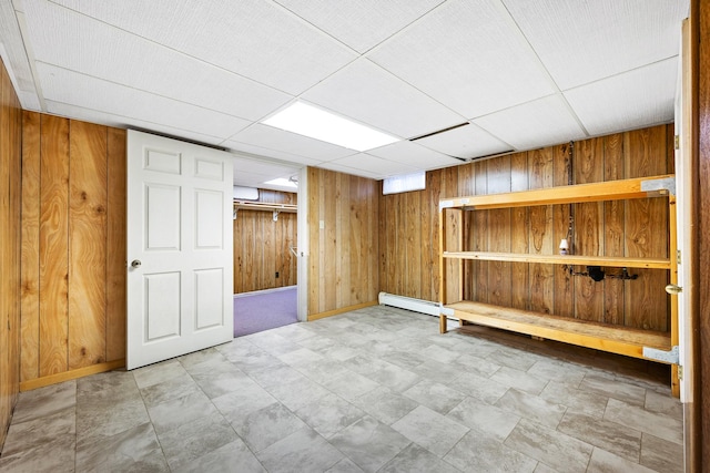 finished basement featuring wooden walls and baseboards
