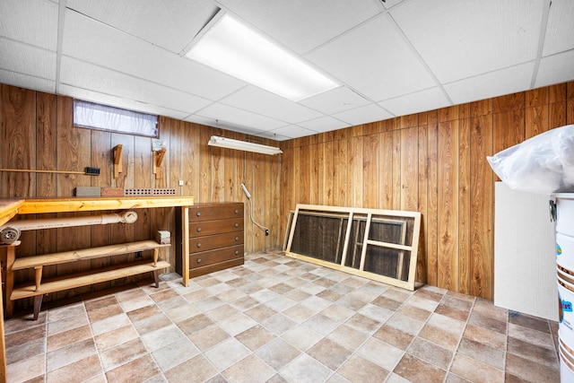 bar with stone finish flooring, a paneled ceiling, and wooden walls