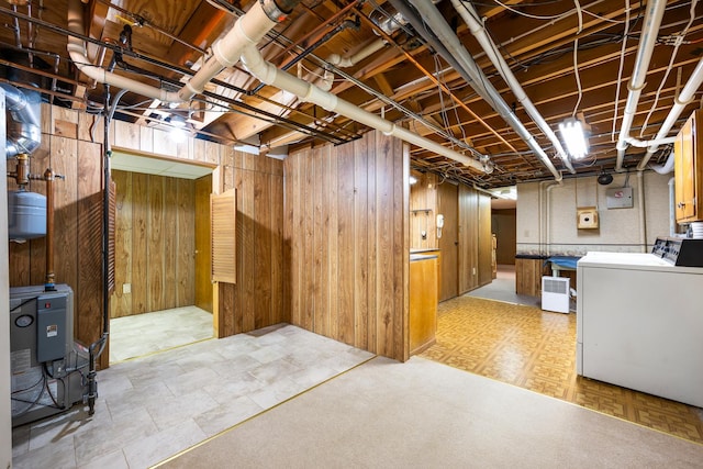unfinished below grade area with wooden walls and washer / dryer