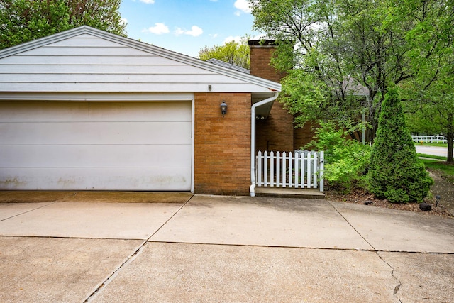 garage with fence and driveway