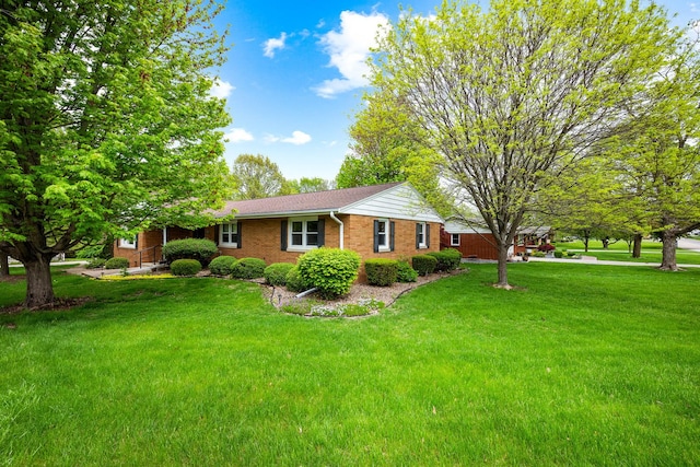 view of side of home featuring a yard and brick siding