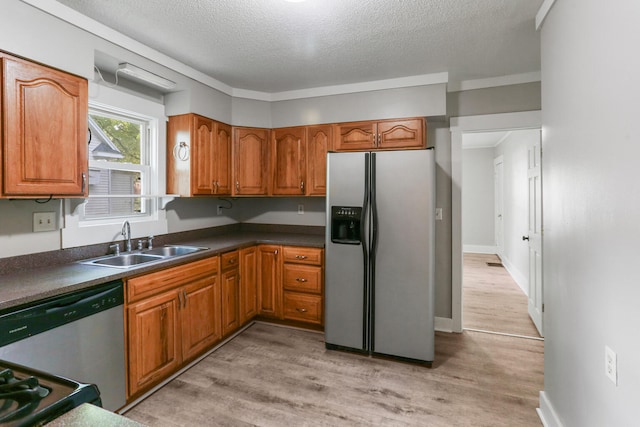 510 S Cottage Grove Ave, Urbana, IL 61802 - kitchen featuring stainless steel appliances, a textured ceiling, brown cabinetry, light wood-type flooring, and dark countertops