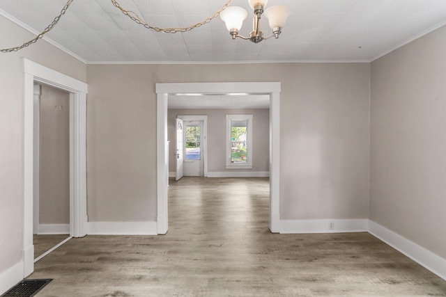 510 S Cottage Grove Ave, Urbana, IL 61802 - spare room featuring wood finished floors, a chandelier, and crown molding