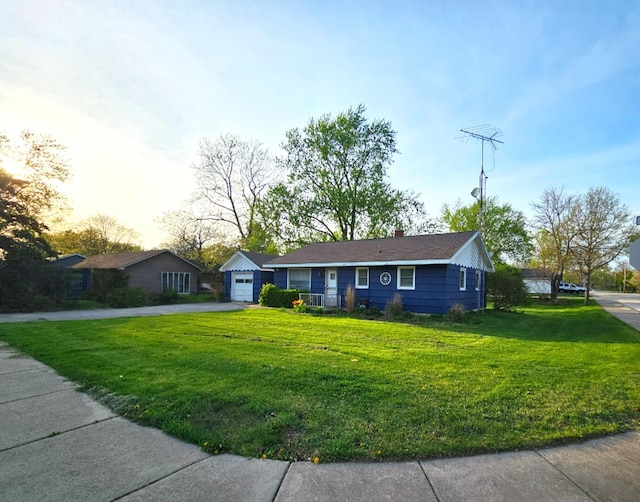 ranch-style house with a detached garage, driveway, a front yard, and a chimney