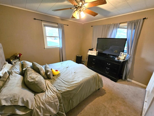 bedroom featuring baseboards, ornamental molding, a ceiling fan, and carpet flooring